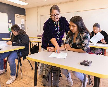 A Navajo woman and high school teacher teaches math to her students in a classroom. Image taken on the Navajo Reservation, Utah, USA.